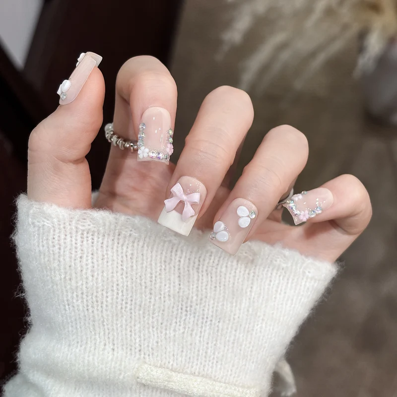 Dekoratives Nagelkunstset mit floralen Details und Schleifenakzenten