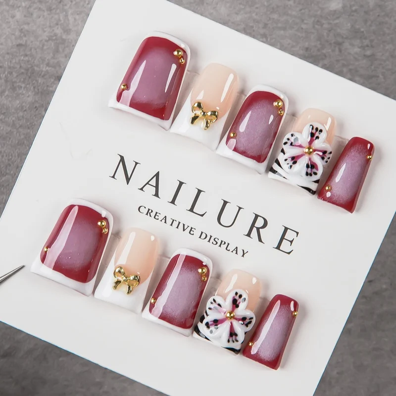 Künstlerisches Press-On Nagelset mit Blumenelementen und Schleifenakzenten