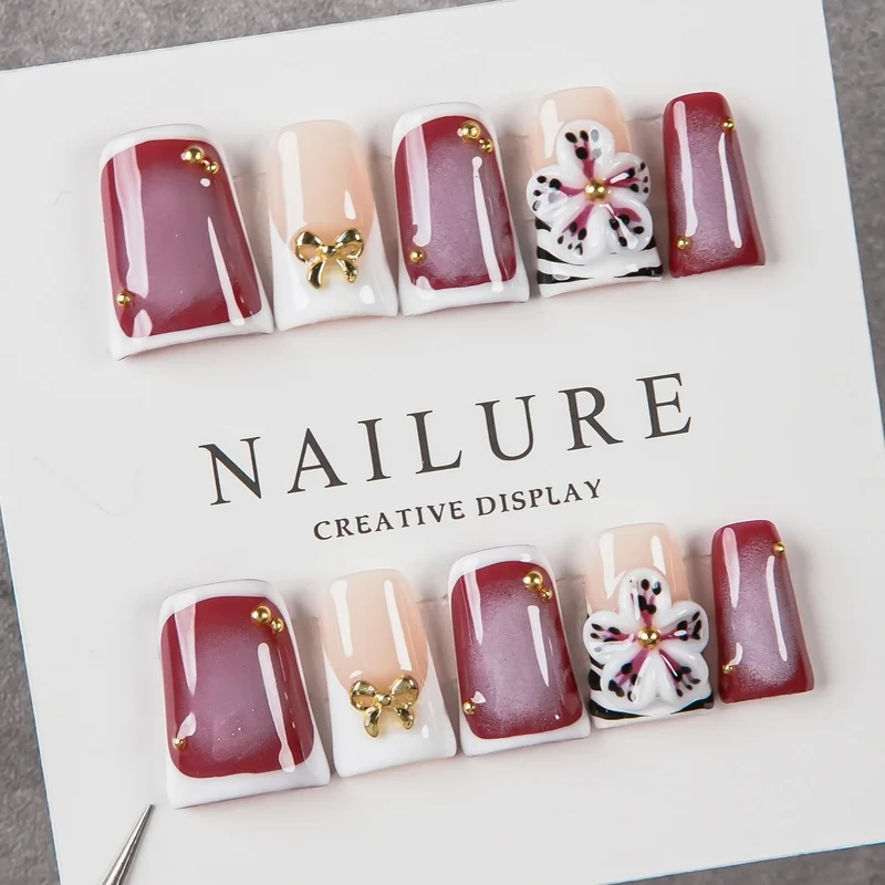 Künstlerisches Press-On Nagelset mit Blumenelementen und Schleifenakzenten