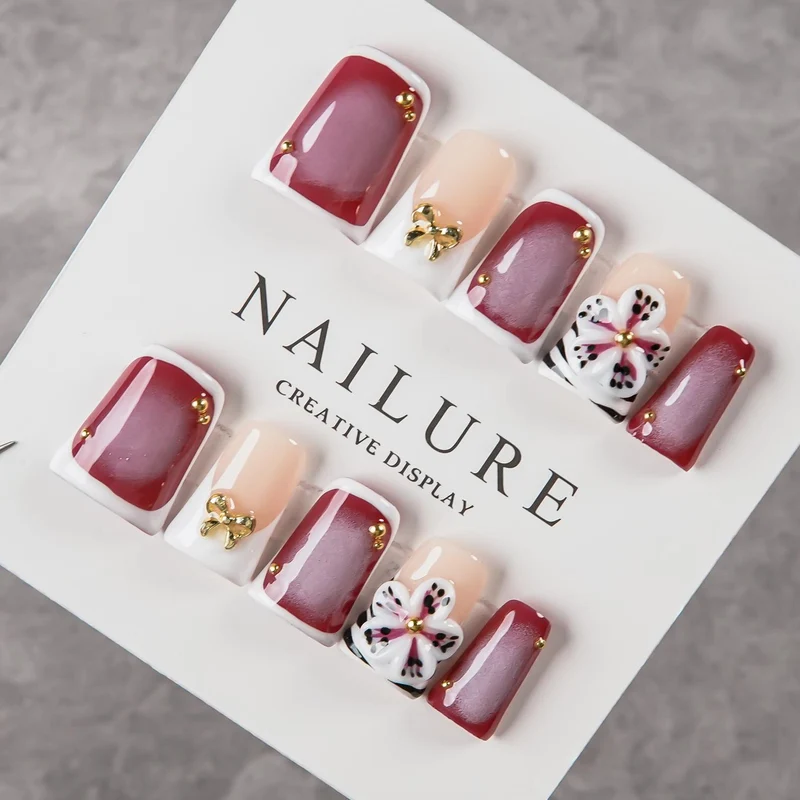 Künstlerisches Press-On Nagelset mit Blumenelementen und Schleifenakzenten