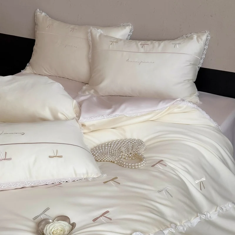 Elegante Bettwäschegarnitur aus seidig-feinem Satin mit bestickten Schleifen und Spitzenbordüre
