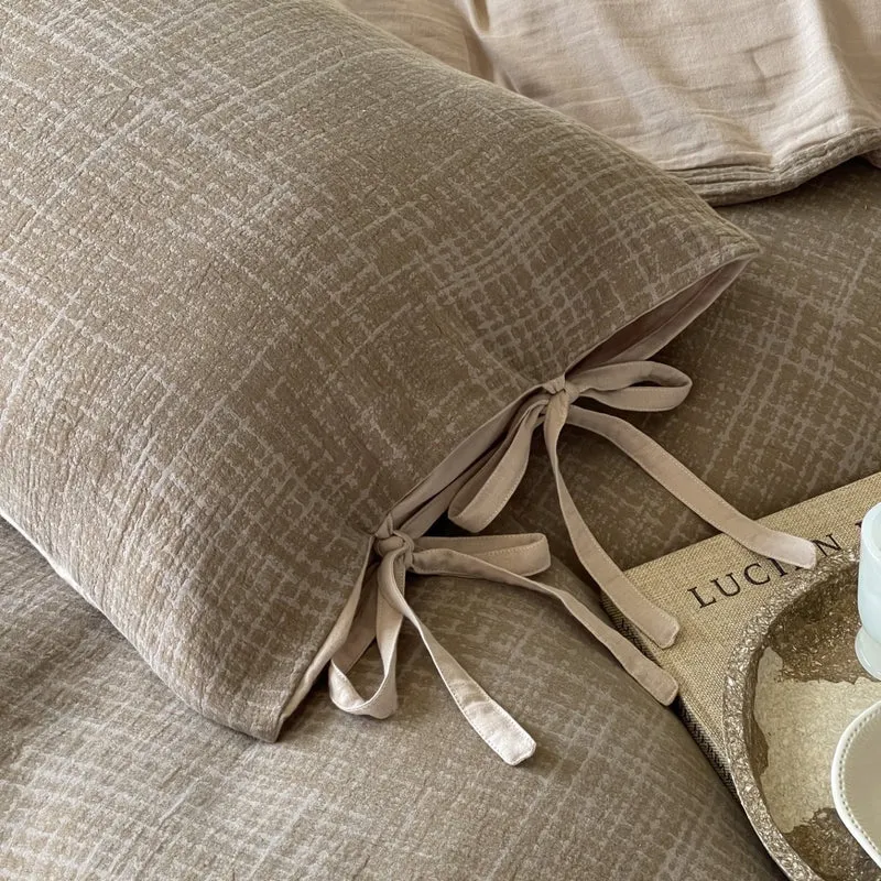 Wendbares Bettwäsche-Set aus Baumwollsatin mit strukturiertem Kreuzmuster und Kissenbezügen mit Bindeband