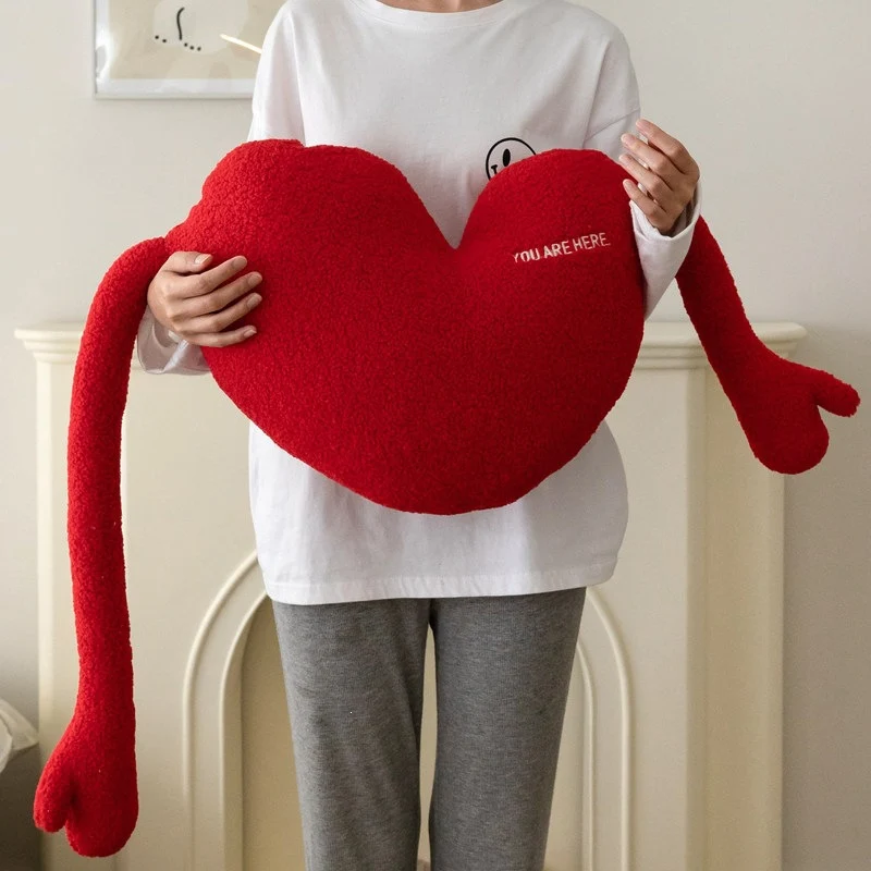 Kuschelkissen in Herzform mit extra langen Armen aus Sherpa‑Fleece und Stickdetail