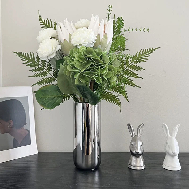 Spiegelnde hohe zylindrische dekorative Metallvase mit künstlicher Hortensie und Protea Arrangement