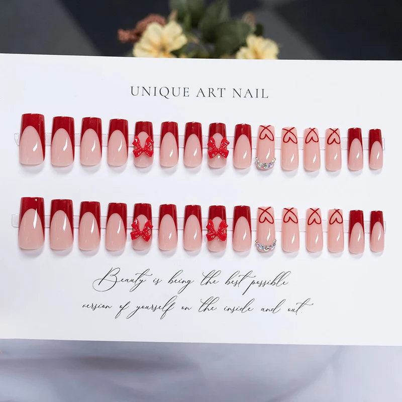 Künstlerisches Press-On Nagelset mit Herz- und Schleifenmotiven