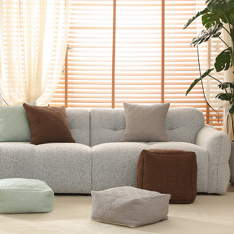 Gepolsterter Fußhocker‑Pouf mit gestepptem Bezugsstoff und formstabilem Kern