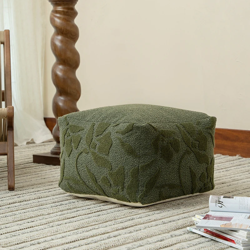 Quadratischer Bodensitzpouf mit strukturierter Bouclé‑Oberfläche und floralem Relief