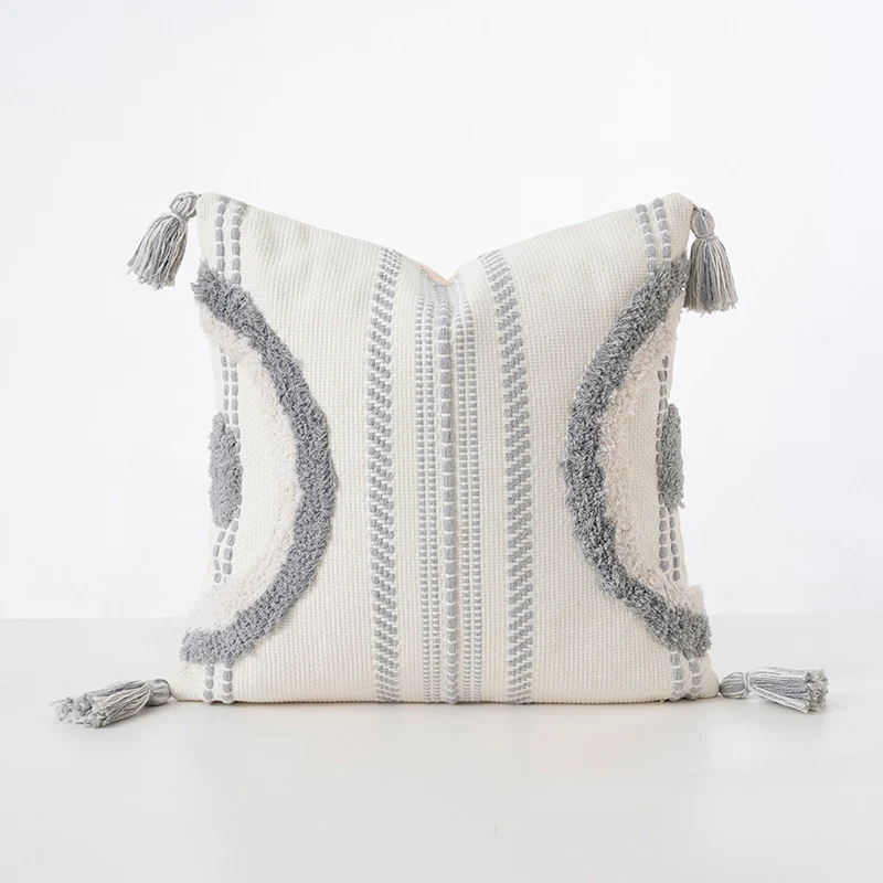 Quadratisches Dekokissen mit Bouclé-Relief, Zickzack- und Rautenmuster sowie Quasten