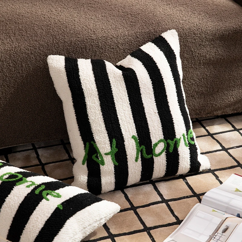 Gestreiftes Bouclé-Dekokissen mit eingesticktem Schriftzug und kuscheliger Füllung