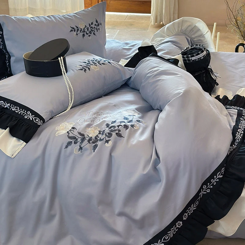 Elegante Bettwäsche-Garnitur aus Baumwollsatin mit Stickerei, kontrastierendem Volant und Rundkissen