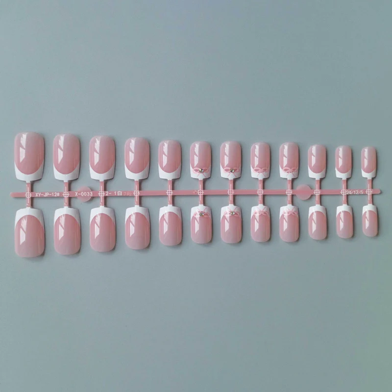 Elegantes French Tip Nagelkunstset mit zarten Schleifenakzenten