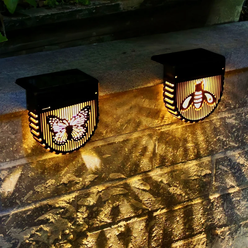 Dekorative solarbetriebene Außenwandleuchten mit lasergeschnittenen Insekten- und Blumenpaneelen und warmer LED-Atmosphäre Skanto