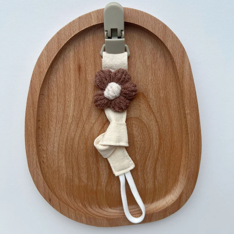 Handgemachter Baumwoll-Schnullerclip mit Gingham-Gurt und gestrickter Blume