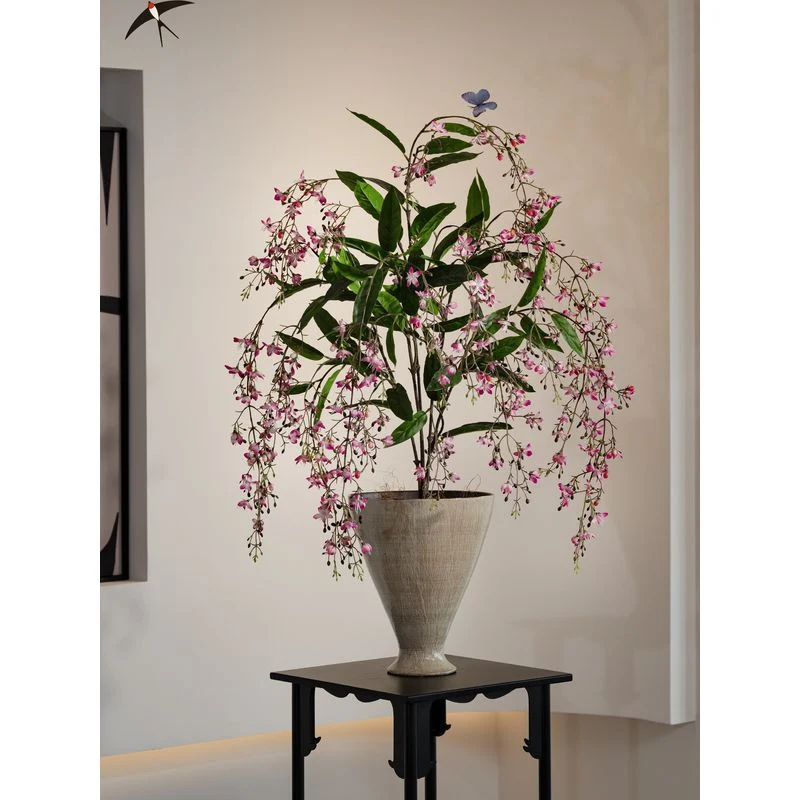 Lebensechte künstliche Blumenarrangement in dekorativem Topf