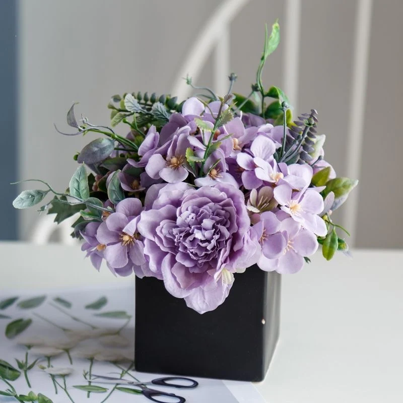 Lebensechte Blumenarrangement in dekorativem quadratischen Pflanzgefäß