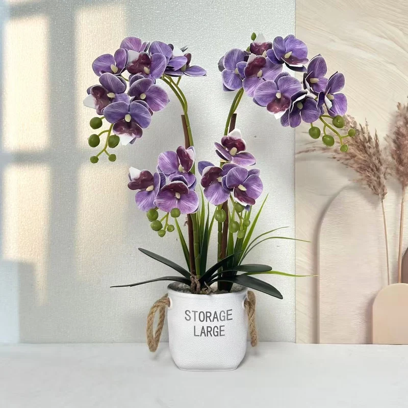 Lebensechte Orchideenpflanze in dekorativem Topf für die Wohnkultur