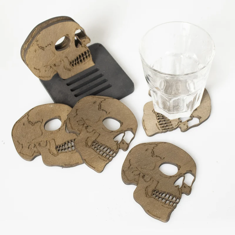 Set aus lasergravierten Holz-Untersetzern in Totenkopf-Form mit Aufbewahrungsständer