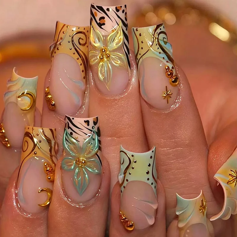 Luxuriöses Kunstnagelset mit kreativen floralem Design und goldenen Akzenten Brehn