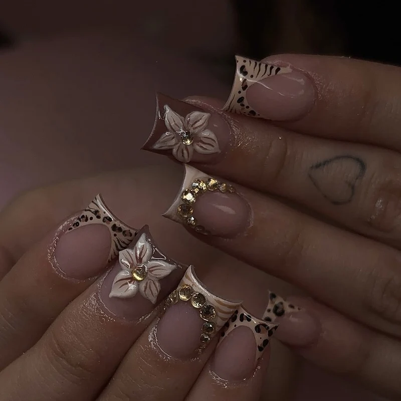 Kunstnagelset mit floralen Verzierungen und eleganten Glitzerdetails Brehn