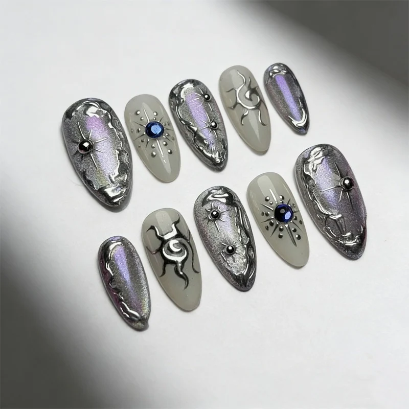 Kunstnagelset mit glänzendem Metallic-Effekt und eleganten Verzierungen Brehn