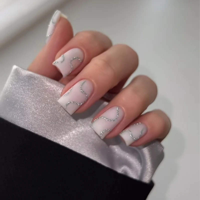Künstliches Nagelset mit eleganten Linien und Glitzerakzenten Brehn
