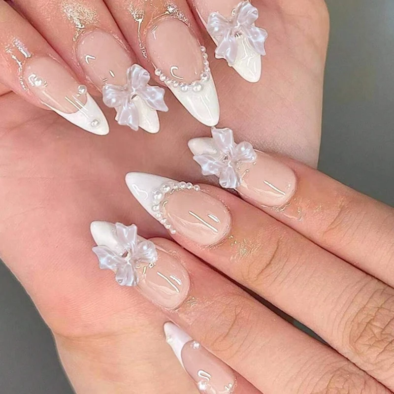 Kreatives Kunstnagelset mit eleganten Schleifen und Perlenelementen Brehn
