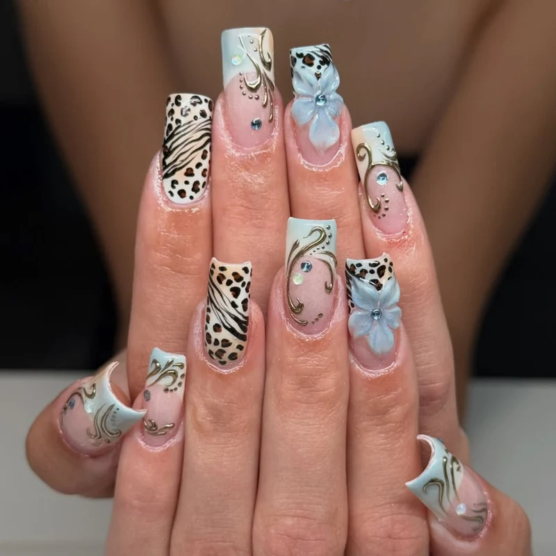 Glamouröses Kunstnagelset mit floralen Akzenten und Glitzerdetails Brehn