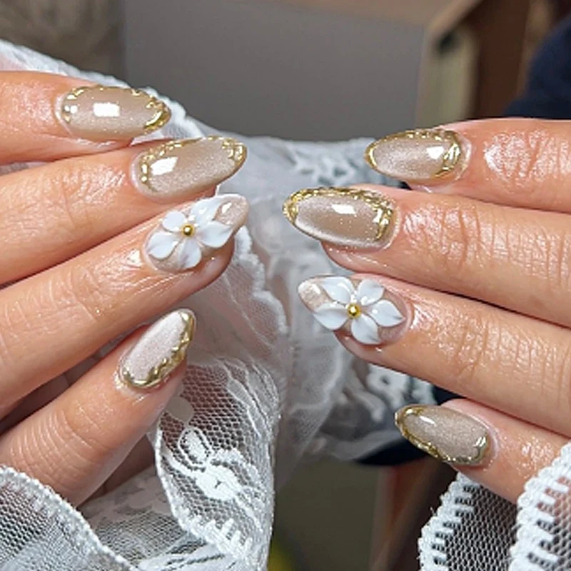 Elegantes Kunstnagelset mit Goldakzenten und Blütenmuster Brehn