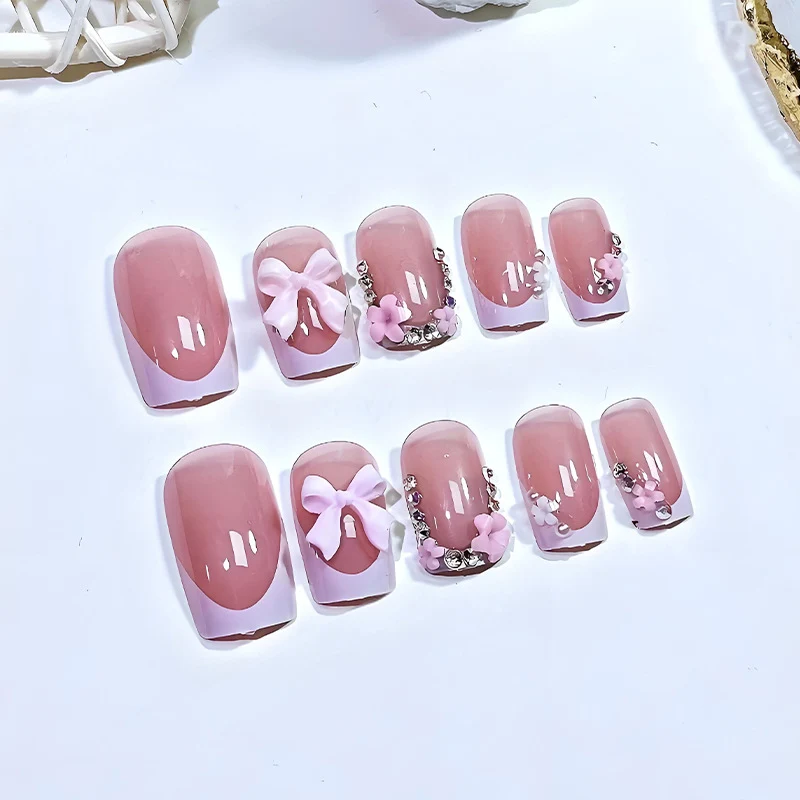 Kunstnagelset mit verspielten Schleifen und eleganten Blütenverzierungen Brehn