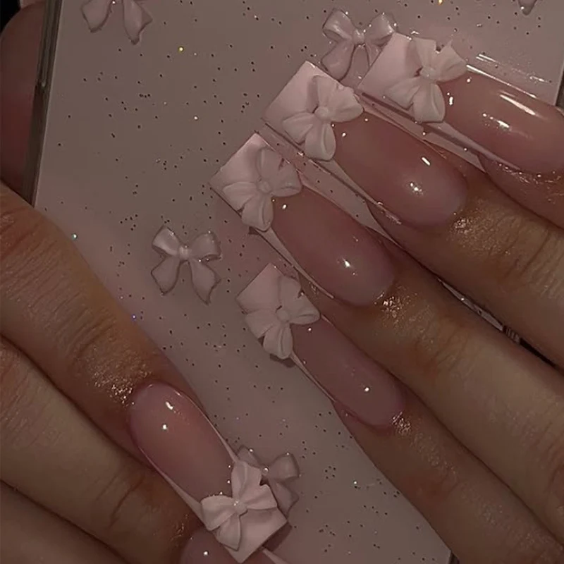 Kunstnagelset mit schimmernden Details und niedlichen Schleifen Brehn