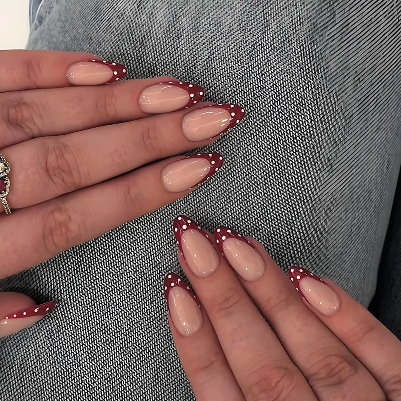 Kunstnagelset mit eleganten roten Spitzen und verspielten Punkten Brehn