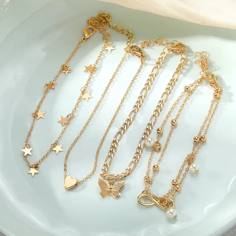 Skanto | 5-teiliges zartes feminines Fußkettchen-Set (Sterne, Herz, Schmetterling, Unendlichkeit, Perlen)